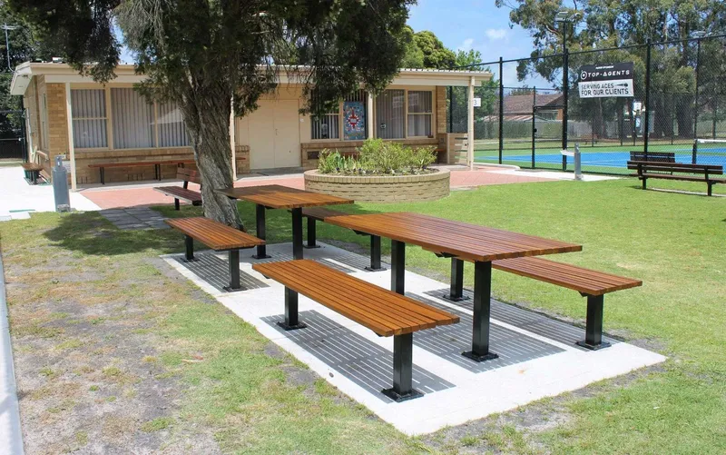 New picnic tables in front of the brick clubhouse