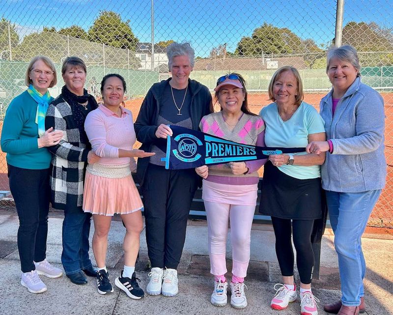 Ladies team group holding a premiers pennant