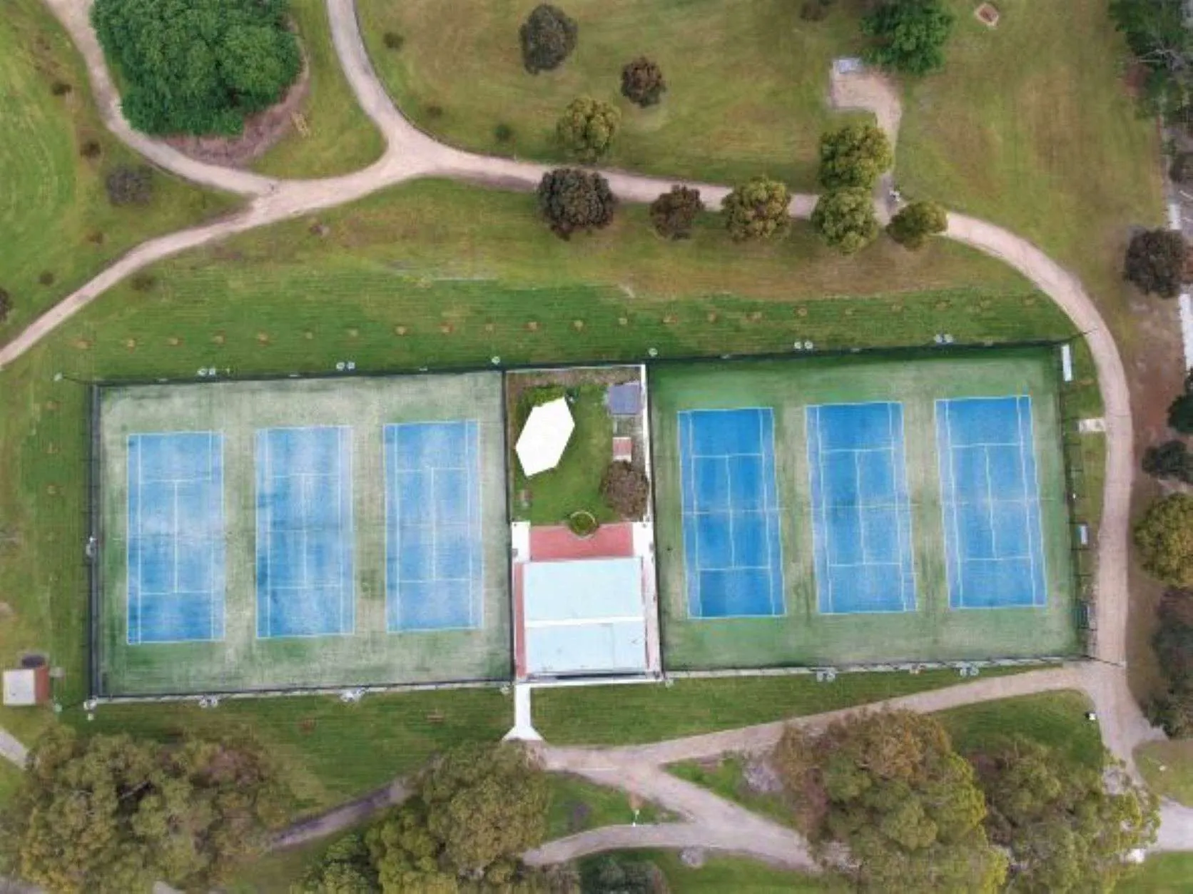 Aerial view of Burden Park Tennis Club's six courts and clubhouse, set among the trees of Burden Park.
