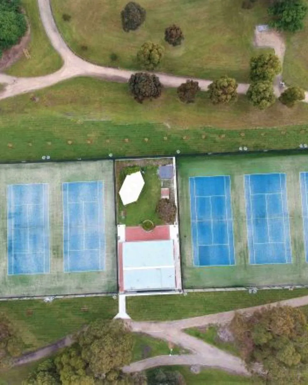Aerial drone photo of all six Burden Park courts and the clubhouse, surrounded by the park's gum trees