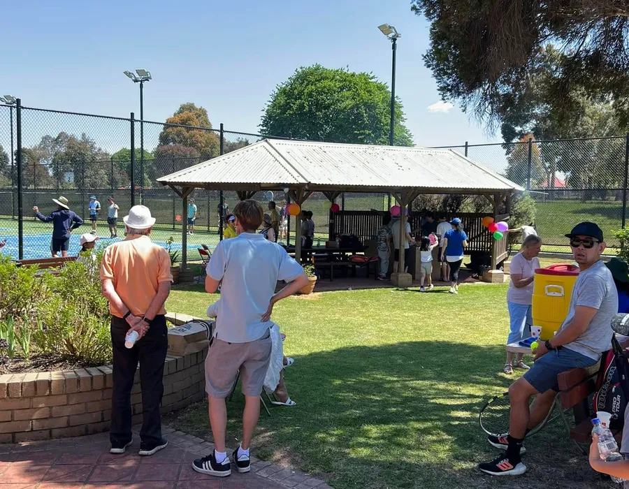 Empty Burden Park courts with the clubhouse and shelter in the background.