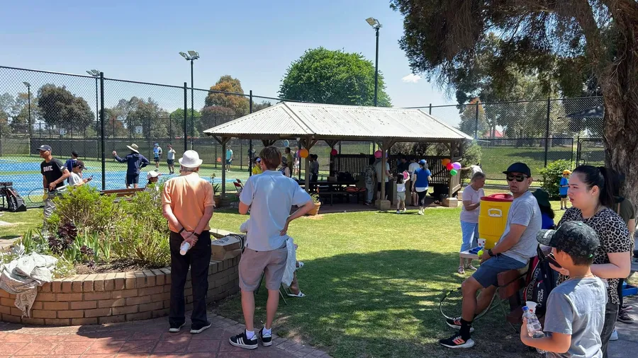 Empty mod-grass courts with the clubhouse and shelter in the background