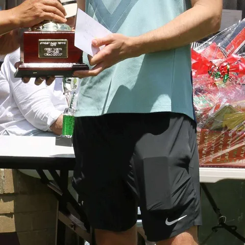 Mark Young holding the Men's Senior Singles trophy.