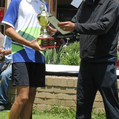 Andrew Louis holding the Boys' Singles trophy.