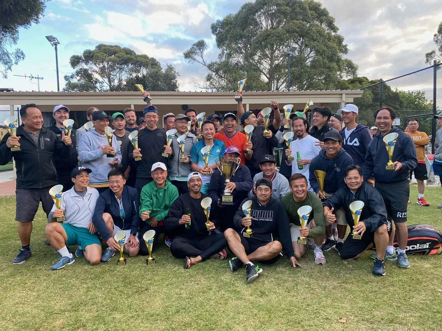 A large group of members gathered at dusk for the AVTA trophy presentation, gum trees behind the clubhouse