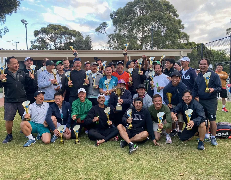 Members and trophy winners gathered at dusk after an AVTA tournament, with gum trees behind the clubhouse.