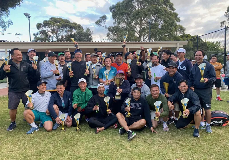 Members and trophy winners gathered at dusk after an AVTA tournament, gum trees behind the clubhouse.